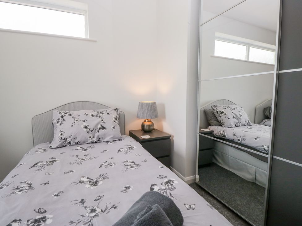 A bedroom with a bed and lamp at Eildon Lodge in Gosforth
