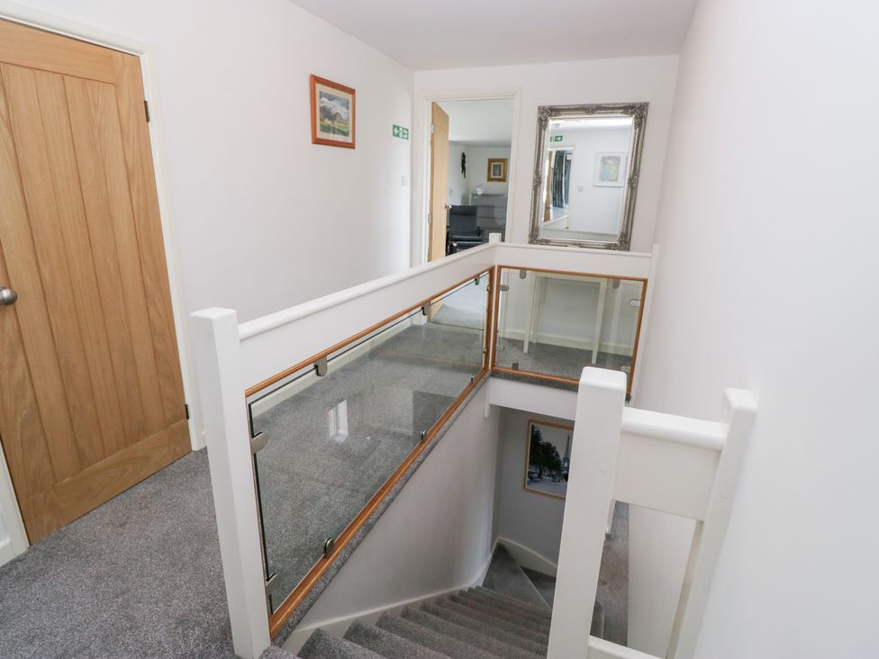A hallway with a staircase and a mirror at Eildon Lodge in Gosforth