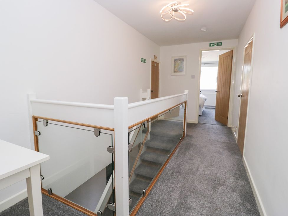 A hallway with a staircase and doors at Eildon Lodge in Gosforth