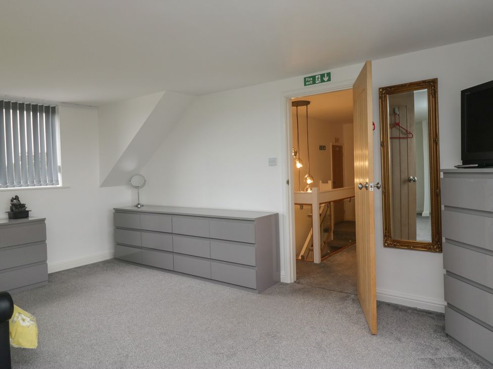 A bedroom with chests of drawers and a mirror at Eildon Lodge in Gosforth