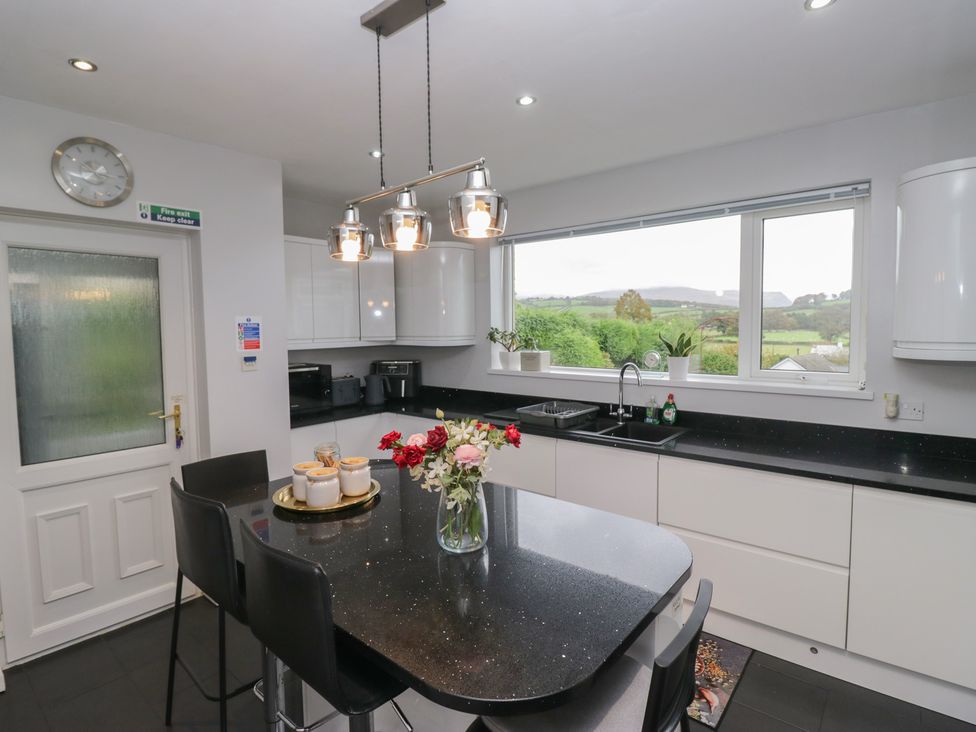 A kitchen with a table, chairs, and a window at Eildon Lodge in Gosforth