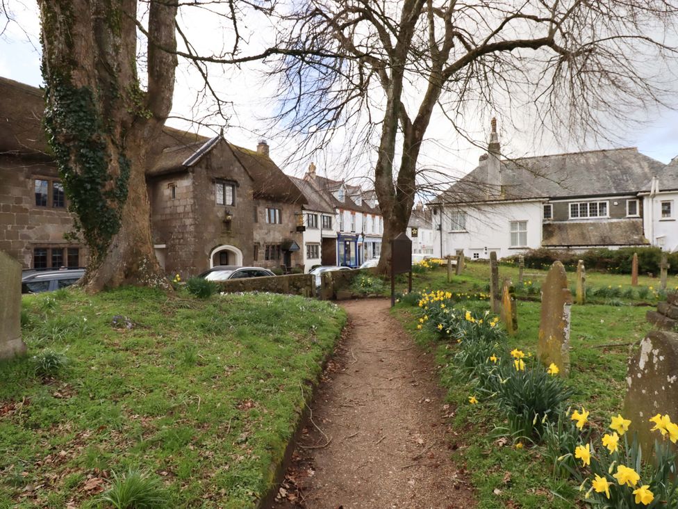 A pathway with trees and graves at Fox Hat Cottage in Chagford