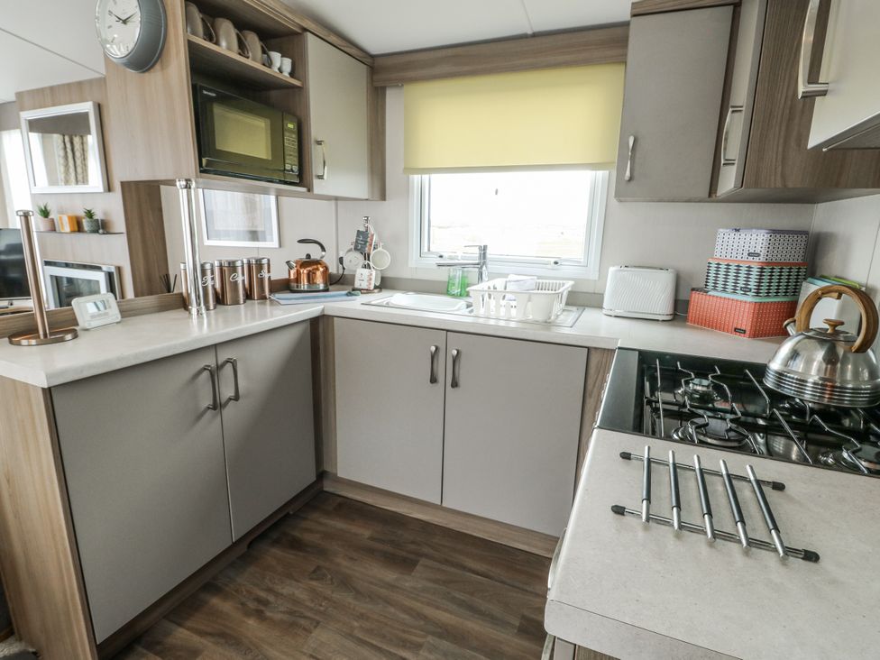 A kitchen with sink and appliances at Trewan Chalet in Bryngwran near Rhosneigr