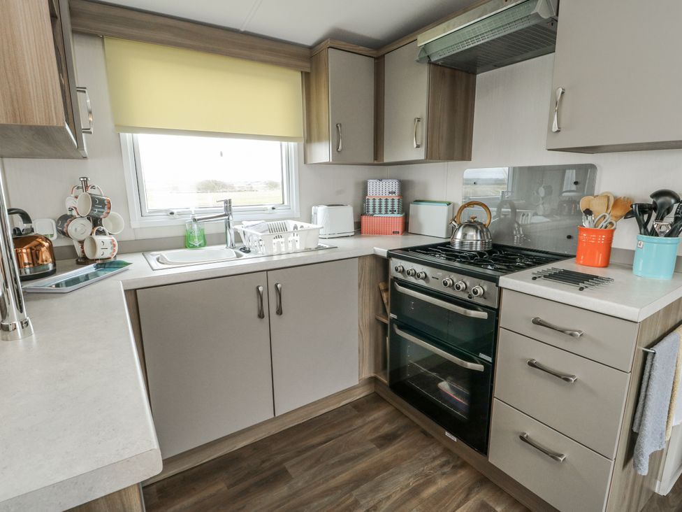 A kitchen with sink and cooking appliances at Trewan Chalet Bryngwran near Rhosneigr