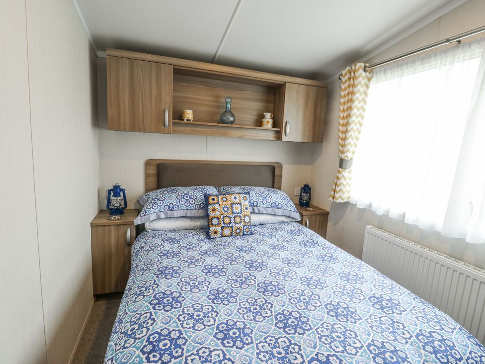 A bedroom with a bed and bedside furniture at Trewan Chalet Bryngwran near Rhosneigr