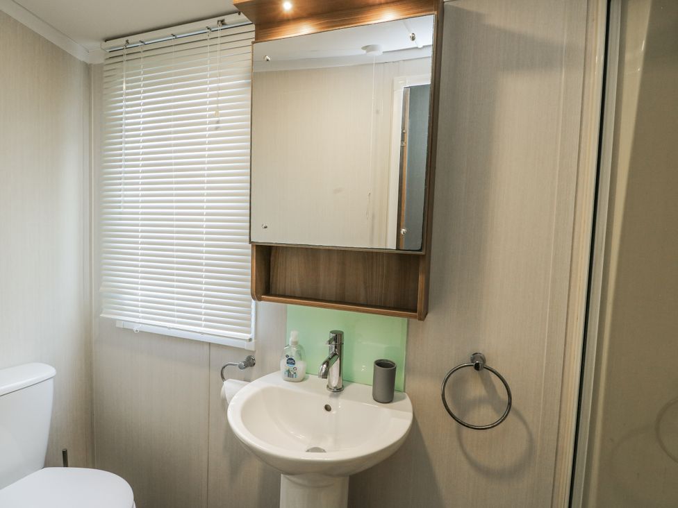A bathroom with a sink and a toilet at Trewan Chalet in Bryngwran near Rhosneigr
