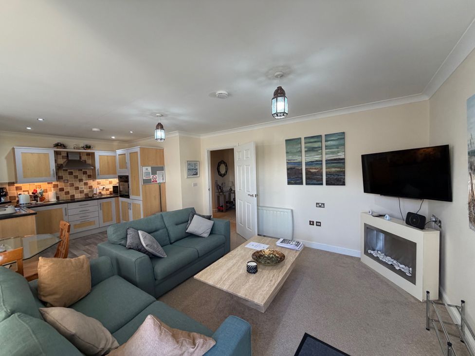 A living room with a coffee table and television at Apartment 1 Middleton near Heysham