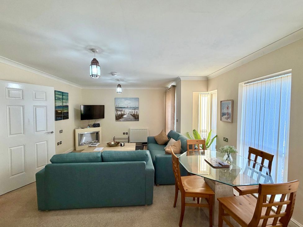A living room with a sofa and dining area at Apartment 1 Middleton near Heysham