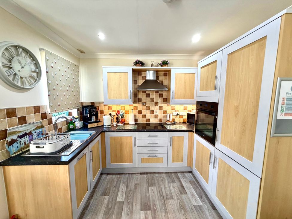 A kitchen with cabinets and appliances at Apartment 1 in Middleton near Heysham