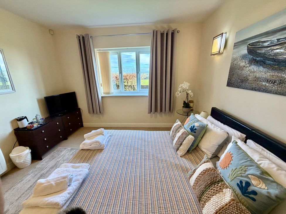 A bedroom with a bed and television at Apartment 1 in Middleton near Heysham