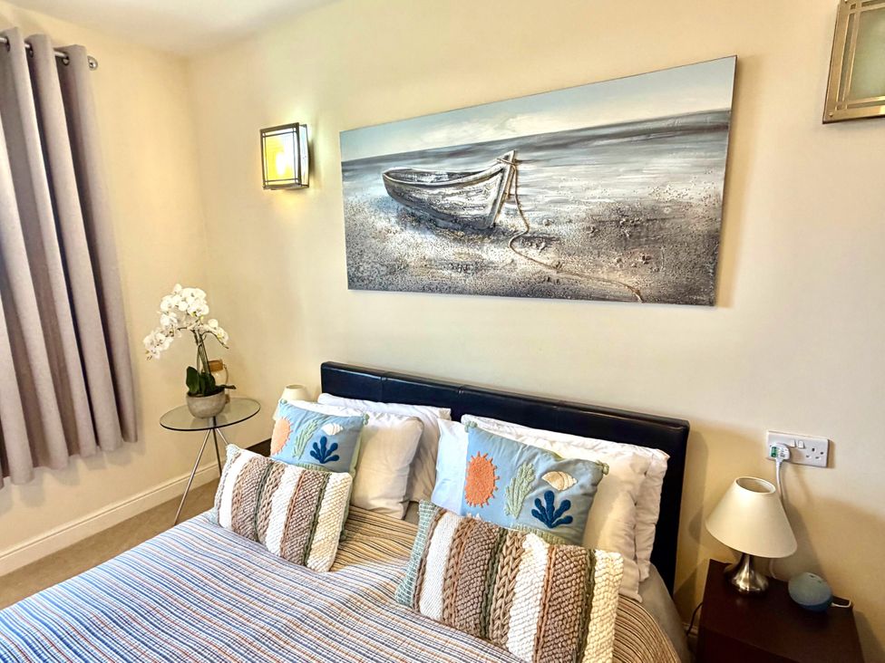 A bedroom with a bed and wall art at Apartment 1 in Middleton near Heysham