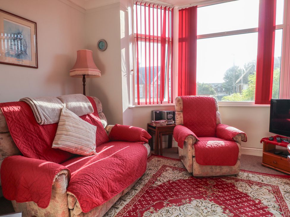 A living room with a sofa and armchair in Sylvian Bexhill-On-Sea