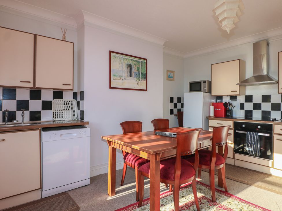 A kitchen with a dining table and chairs at Sylvian in Bexhill-On-Sea