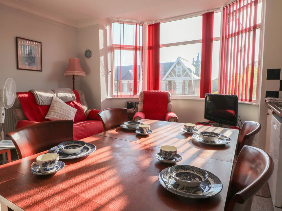 A dining room with a table set for tea at Sylvian in Bexhill-On-Sea