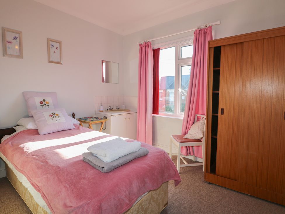 A bedroom with a bed and wardrobe at Sylvian in Bexhill-On-Sea