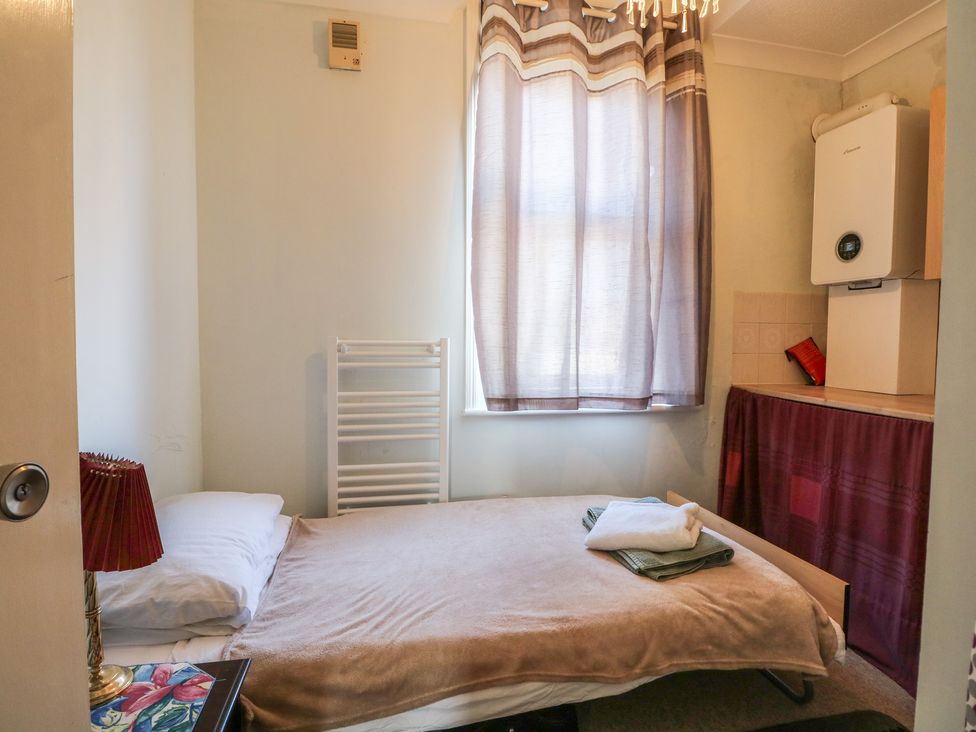 A bedroom with a bed, radiator, and boiler at Sylvian in Bexhill-On-Sea