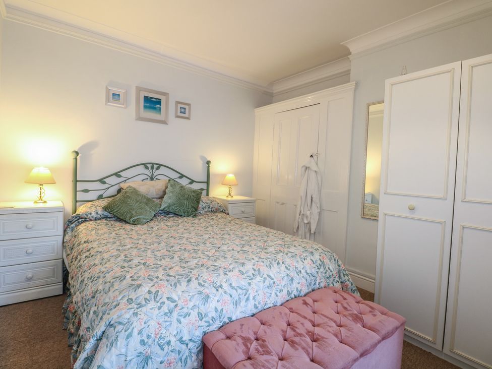 A bedroom with a bed and nightstands at Sylvian in Bexhill-On-Sea