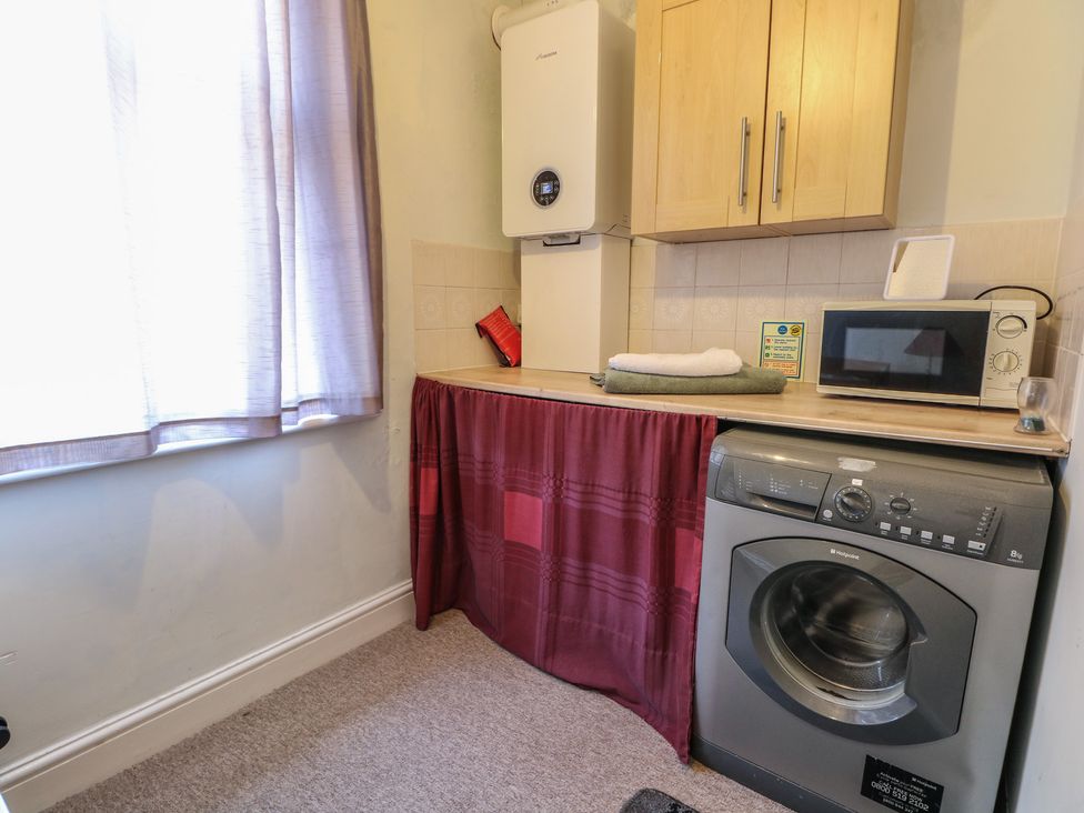 A laundry room with washing machine and microwave at Sylvian in Bexhill-On-Sea