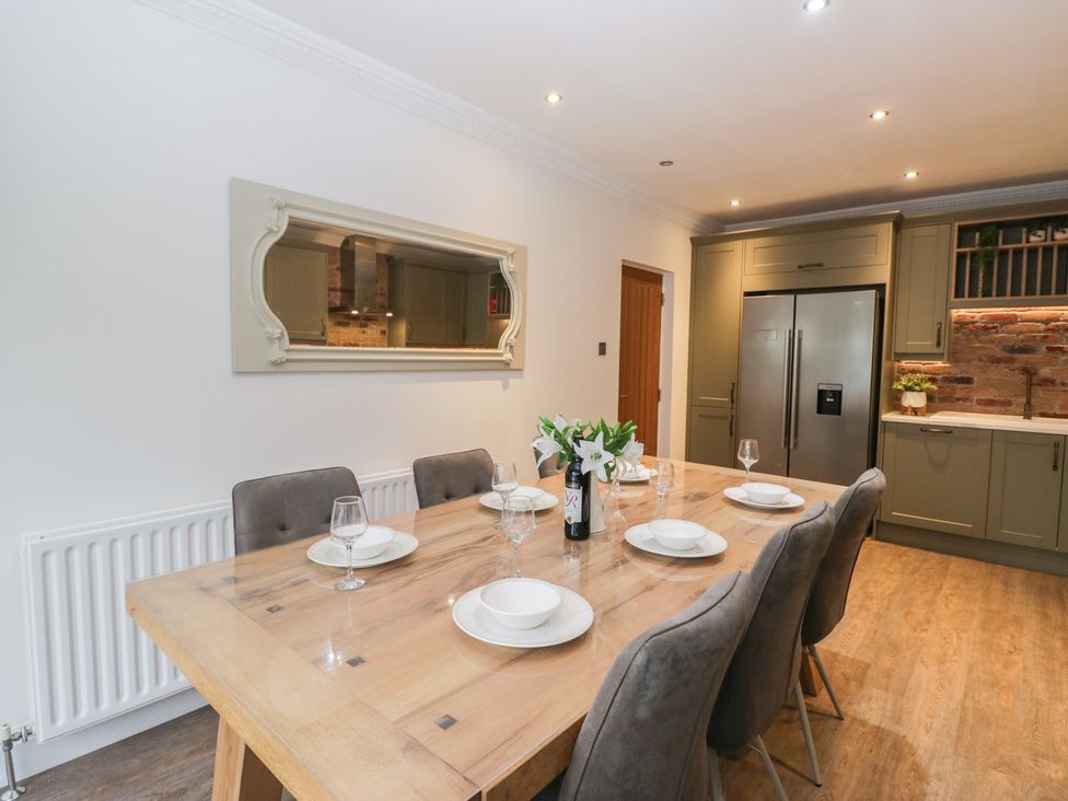 A dining room with a table set for dinner at Chestnuts Cottage in Windermere
