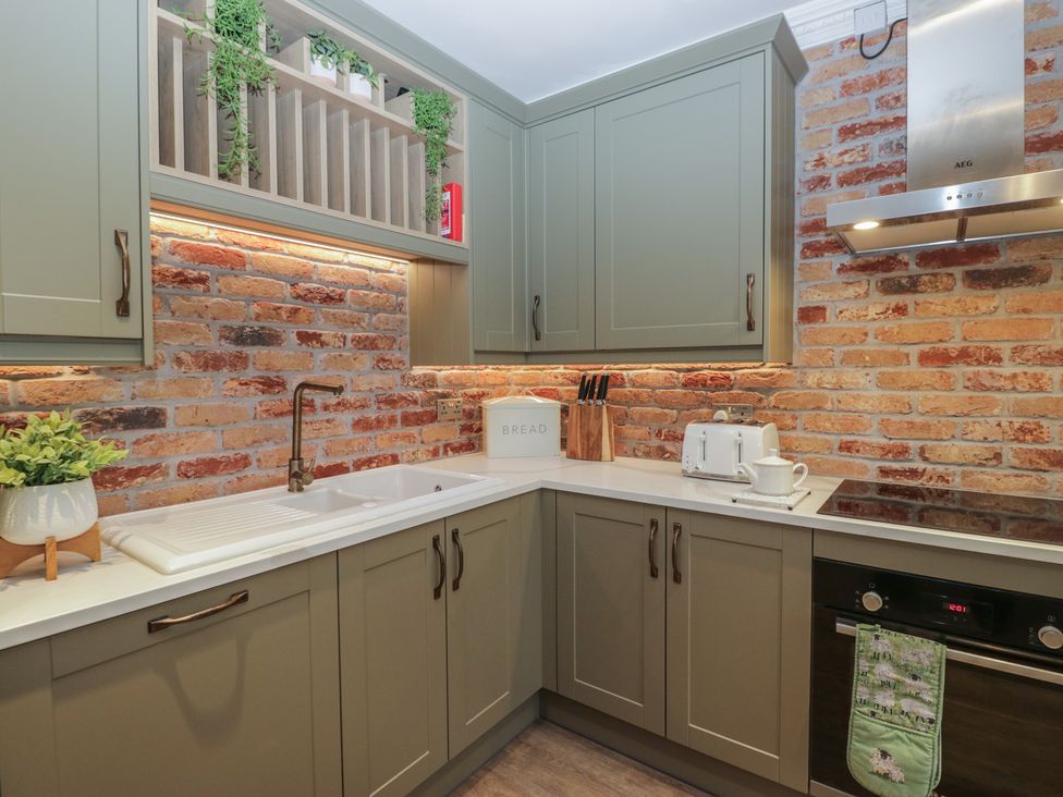 A kitchen with cabinets and a sink at Chestnuts Cottage in Windermere