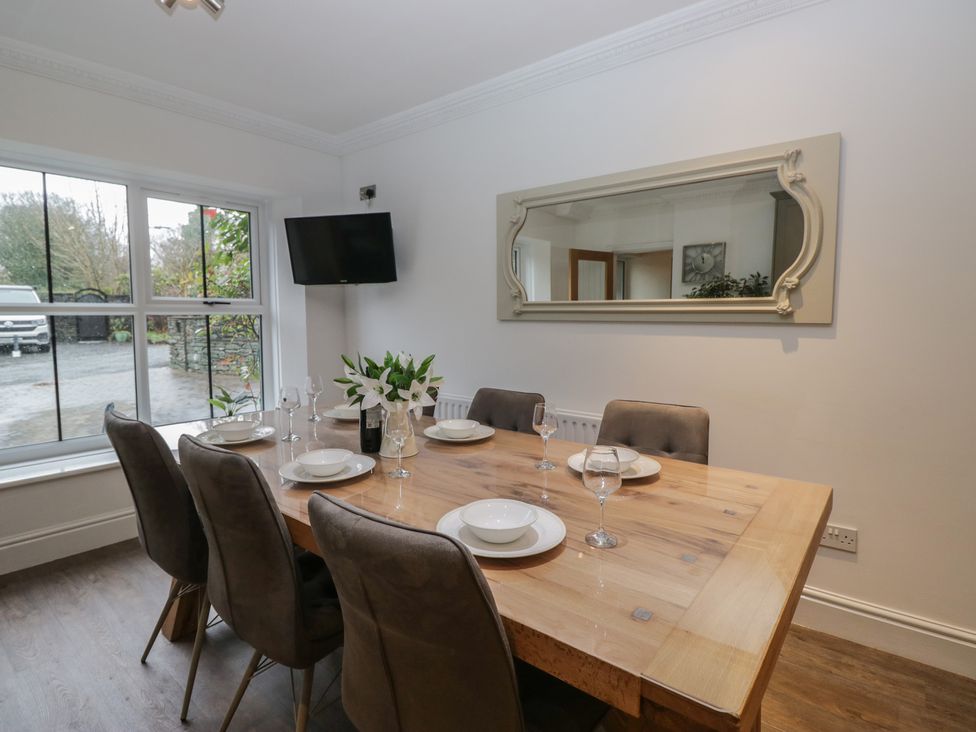 A dining room with a table set for dinner at Chestnuts Cottage in Windermere