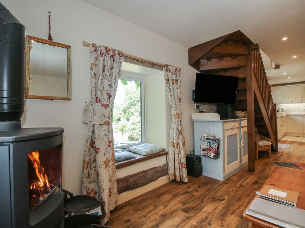 A living room with a stove and staircase at Buzzards Breg in Builth Wells