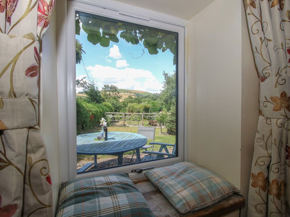 A window view with a garden and seating area at Buzzards Breg in Builth Wells