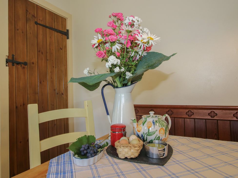 A kitchen table with flowers in a vase at Buzzards Breg in Builth Wells
