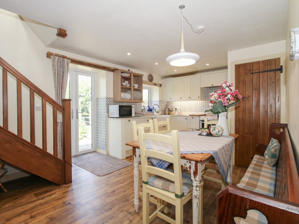 A kitchen with a dining table and a staircase at Buzzards Breg in Builth Wells