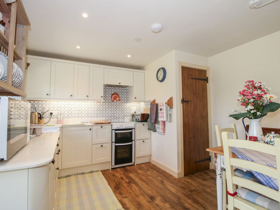 A kitchen with cabinets, oven, and table at Buzzards Breg in Builth Wells