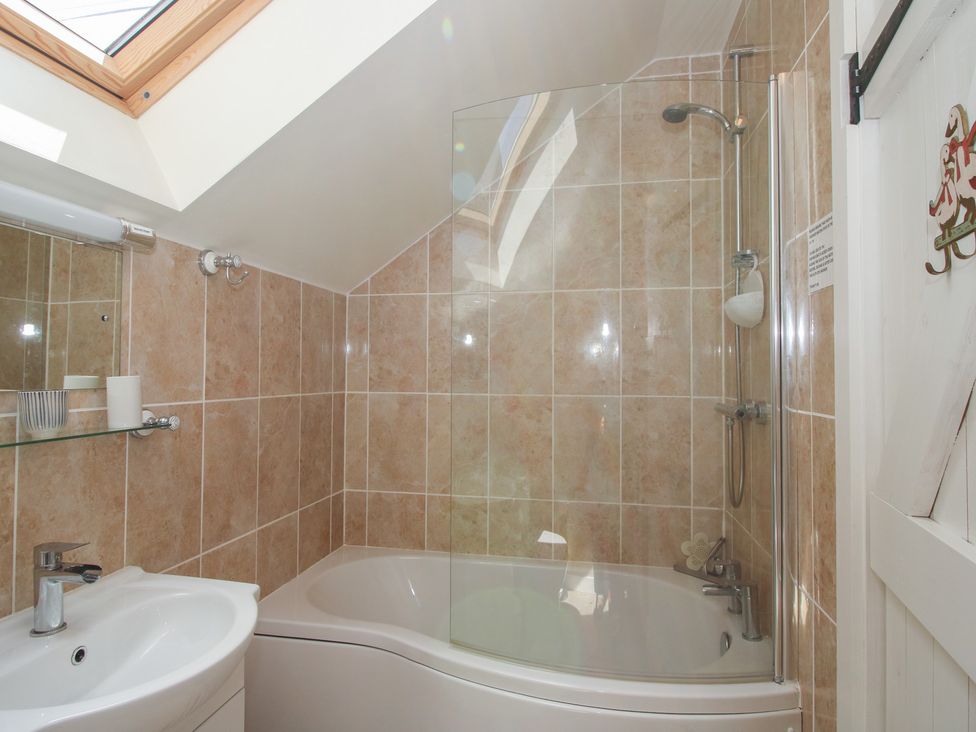 A bathroom with a bathtub and shower at Buzzards Breg in Builth Wells