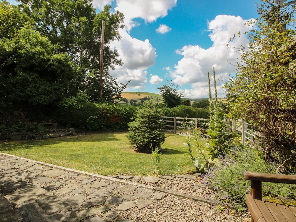A garden with grass and trees at Buzzards Breg in Builth Wells