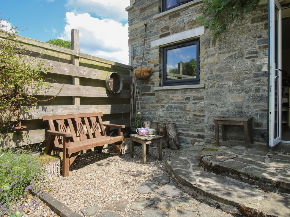 A garden with a bench and table outside at Buzzards Breg in Builth Wells