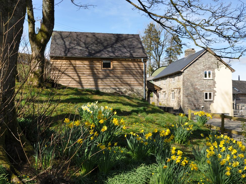 A view of buildings and flowers at Rockhill Farmhouse in Clun