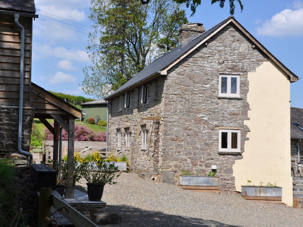 A house with stone walls and gravel area at Rockhill Farmhouse in Clun