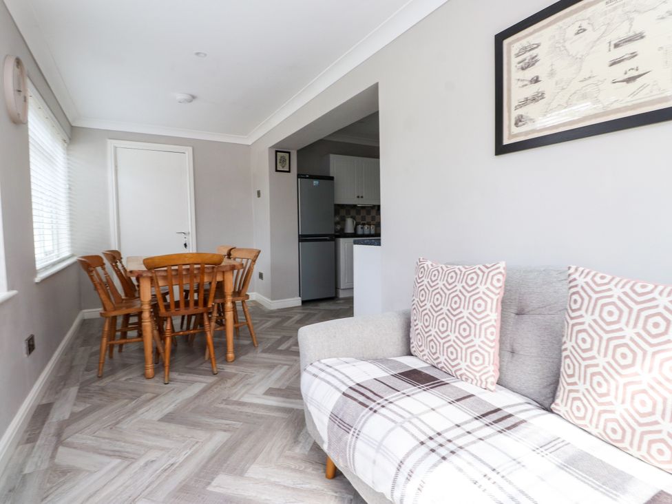A dining room with a table and chairs at 3 Tai Newydd Llanfaelog near Rhosneigr