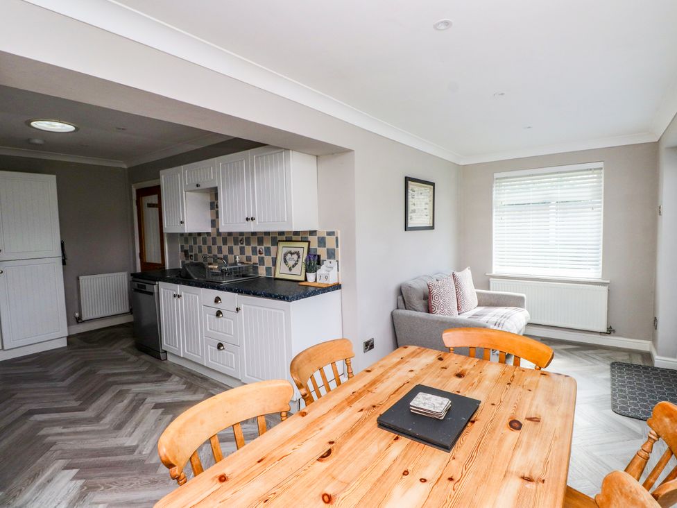 A kitchen with a dining table and chairs at 3 Tai Newydd Llanfaelog near Rhosneigr