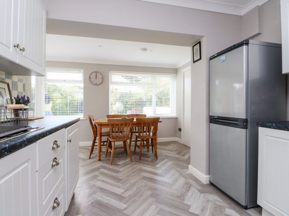 A kitchen with a table and chairs at 3 Tai Newydd Llanfaelog near Rhosneigr