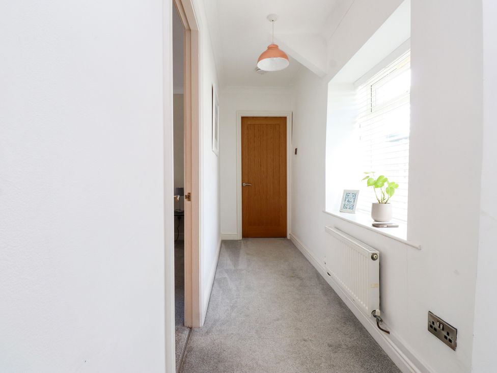 A hallway with a door and window at 3 Tai Newydd Llanfaelog near Rhosneigr