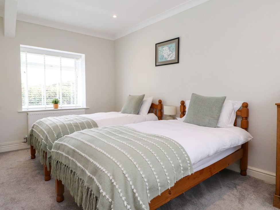 A bedroom with twin beds and a window at 3 Tai Newydd in Llanfaelog near Rhosneigr