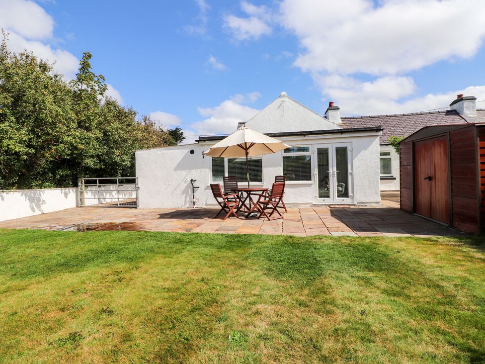 An outdoor area with a table and chairs at 3 Tai Newydd in Llanfaelog near Rhosneigr