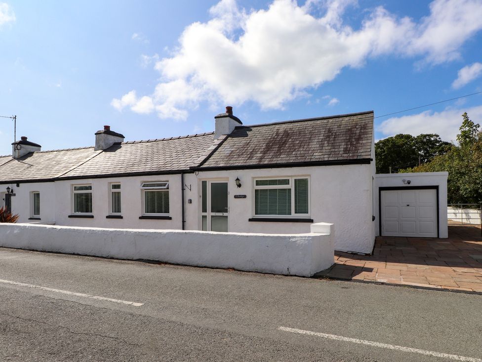 A bungalow with a garage and wall at 3 Tai Newydd Llanfaelog near Rhosneigr