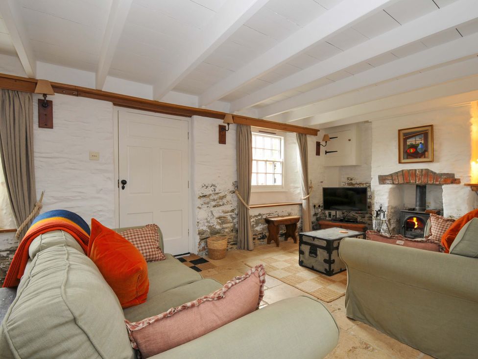 A living room with a sofa and fireplace at Island House in Golant near Tywardreath