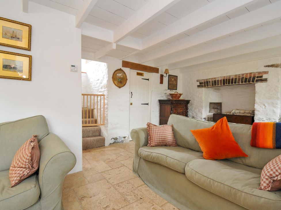 A living room with a couch and staircase at Island House in Golant near Tywardreath
