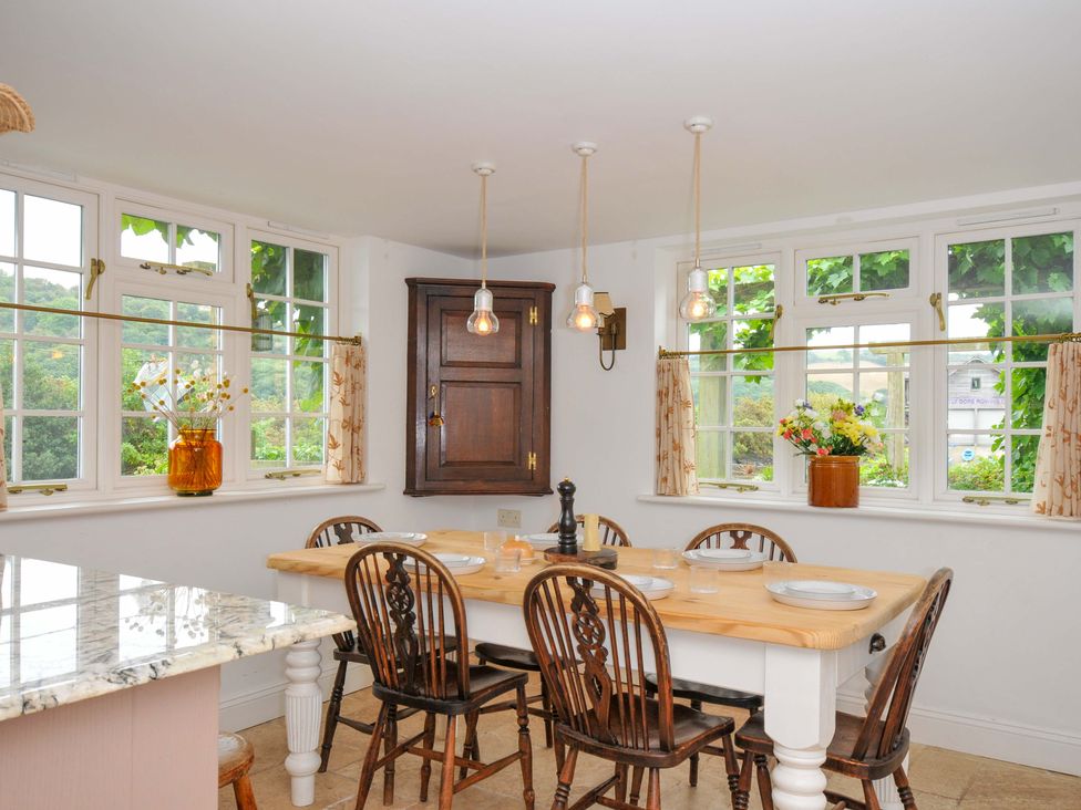 A kitchen with a dining table and chairs at Island House in Golant near Tywardreath