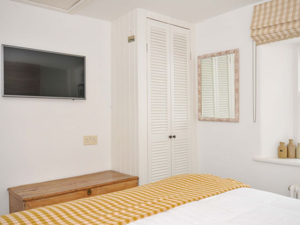 A bedroom with a television and wardrobe at Island House in Golant near Tywardreath