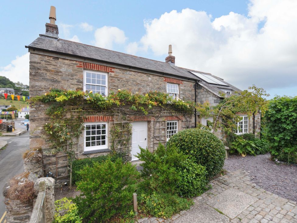 A stone cottage with a garden and pathway at Island House in Golant near Tywardreath