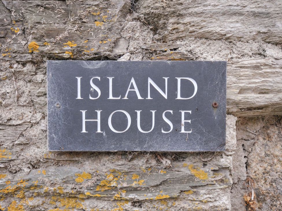 A sign with the name Island House on a stone wall at Island House in Golant near Tywardreath