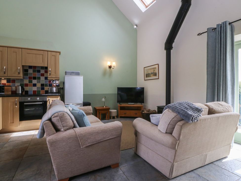 A living room with a sofa and television at No 1 The Granary Capel Coch near Llannerch-Y-Medd