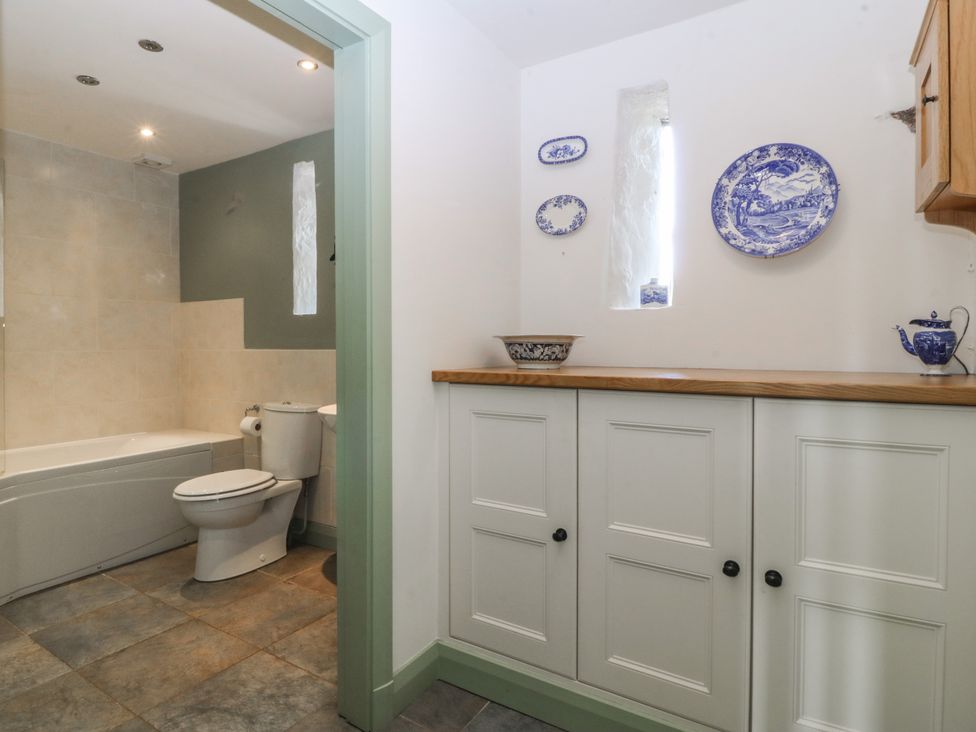 A bathroom featuring a bathtub and toilet at No 1 The Granary near Llannerch-Y-Medd